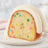 Confetti slice showing topped with signature frosting and funfetti inside the slice of cake