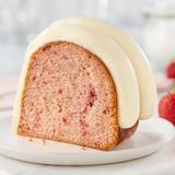 White Chocolate Raspberry slice showing topped with signature frosting and raspberry swirl inside the cake slice