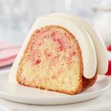 White Chocolate Raspberry slice showing topped with signature frosting and raspberry swirl inside the cake slice