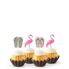 Mini bundt cakes decorated with a topper: from left to right, there's a pair of green tropical flip-flops, a pink flamingo, another pair of pink flip-flops with green straps, and another pink flamingo.