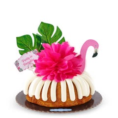 A White Chocolate Raspberry bundt cake decorated with a pink flamingo with tropical leaves. It also includes a card that reads Party in Paradise. 